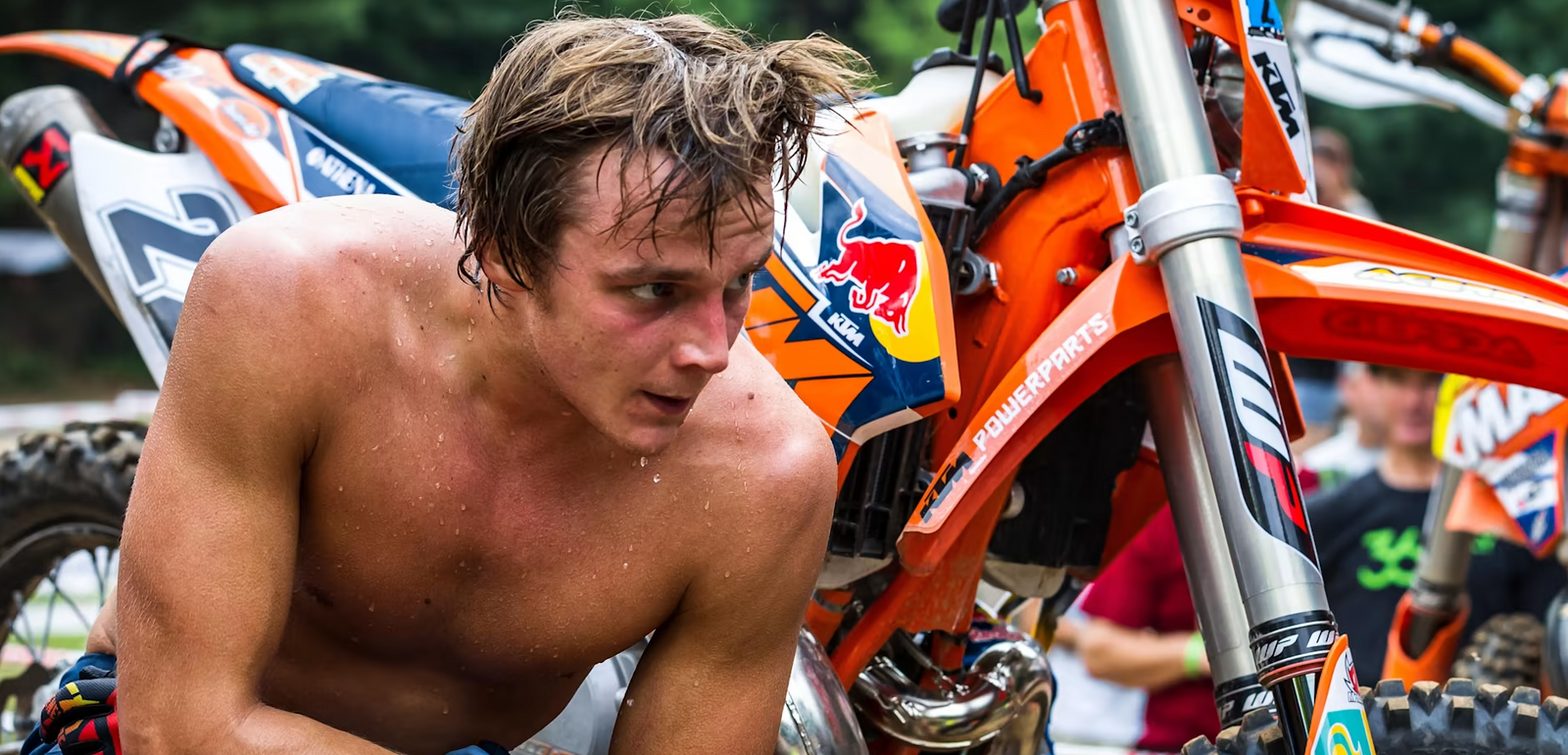 Professional Hard enduro rider, Johnny walker profusely sweating after a training session. Walker sits in front of his ktm dirt bike.