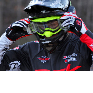 male motocross racer wearing black helmet, Risk Racing V3 goggles, and using hands his to adjust the Ripper Auto Roll-Off system